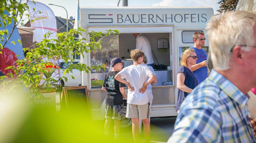 Drei Kinder stehen vorm Eiswagen