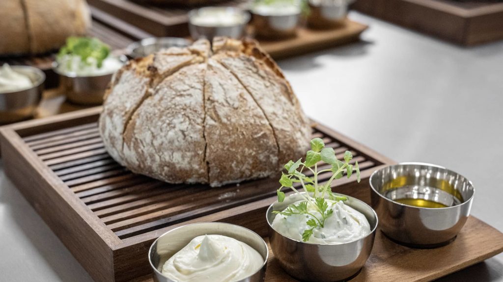 Brot auf Holzbrett mit Dips und Butter