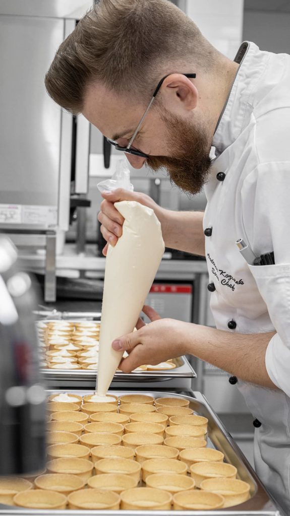 Koch befüllt Tartes mit Füllung