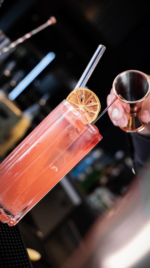 Roter Cocktail mit Garnitur wird eingegossen